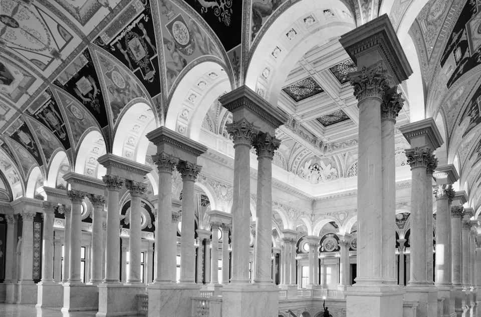 Black-and-white view through the marble columns and vaulted, painted ceilings of the Great Hall in the Library of Congress Thomas Jefferson Building