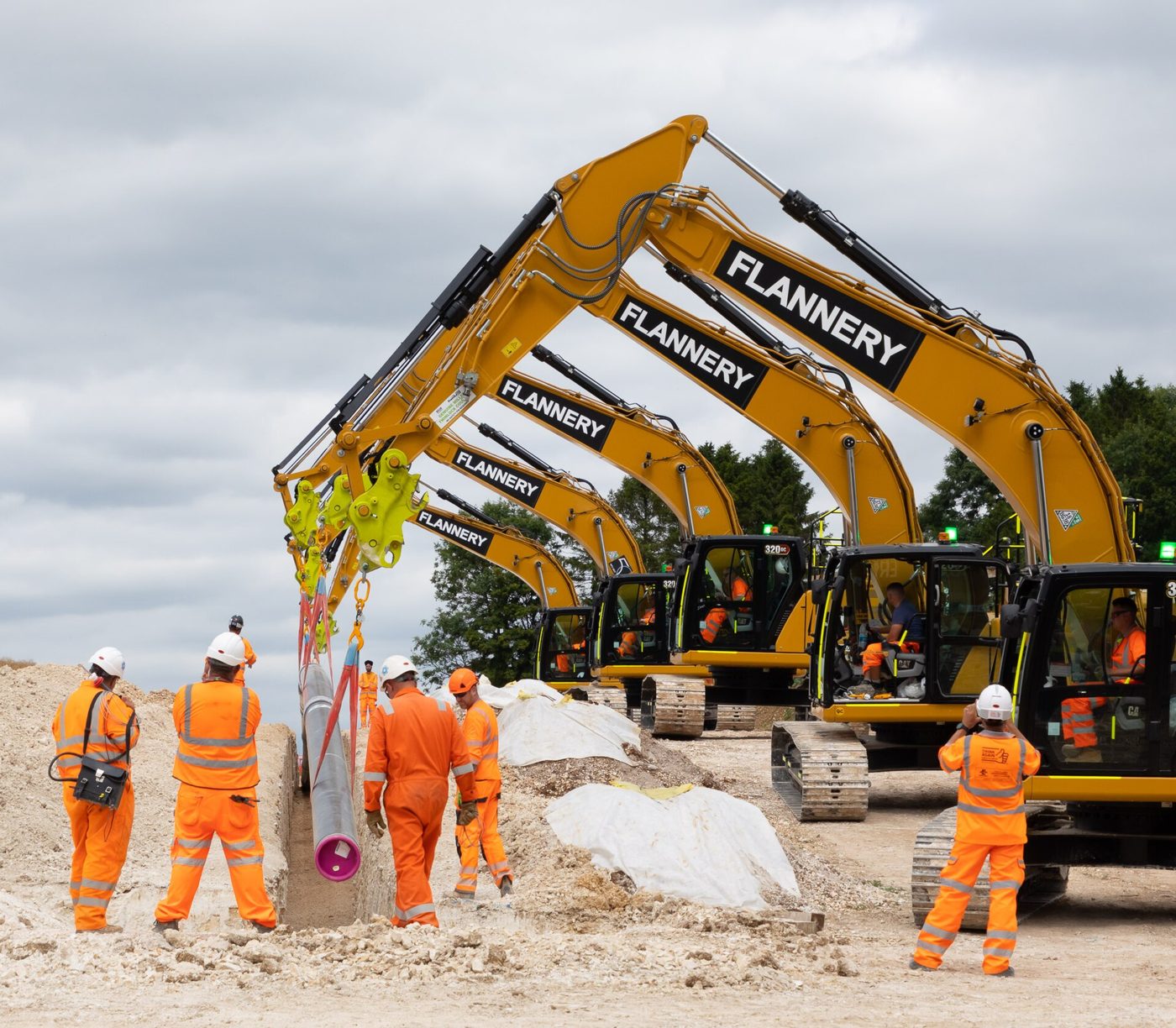 Workers lower pipe into a trench during pipeline construction (file photo, United Kingdom)