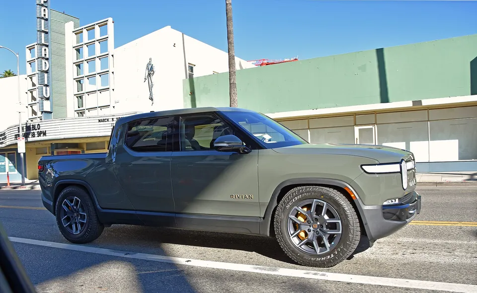 A green Rivian R1T electric pickup parked on Sunset Boulevard in Los Angeles