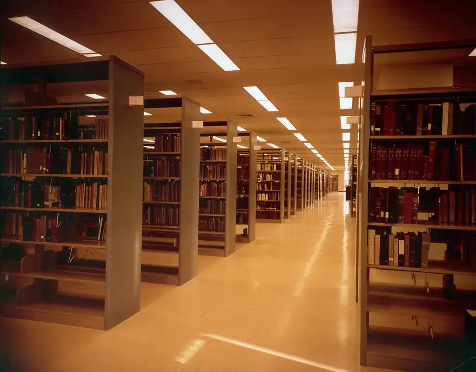 Interior of University of Texas at Arlington Library, tables, chairs, bookshelf stacks