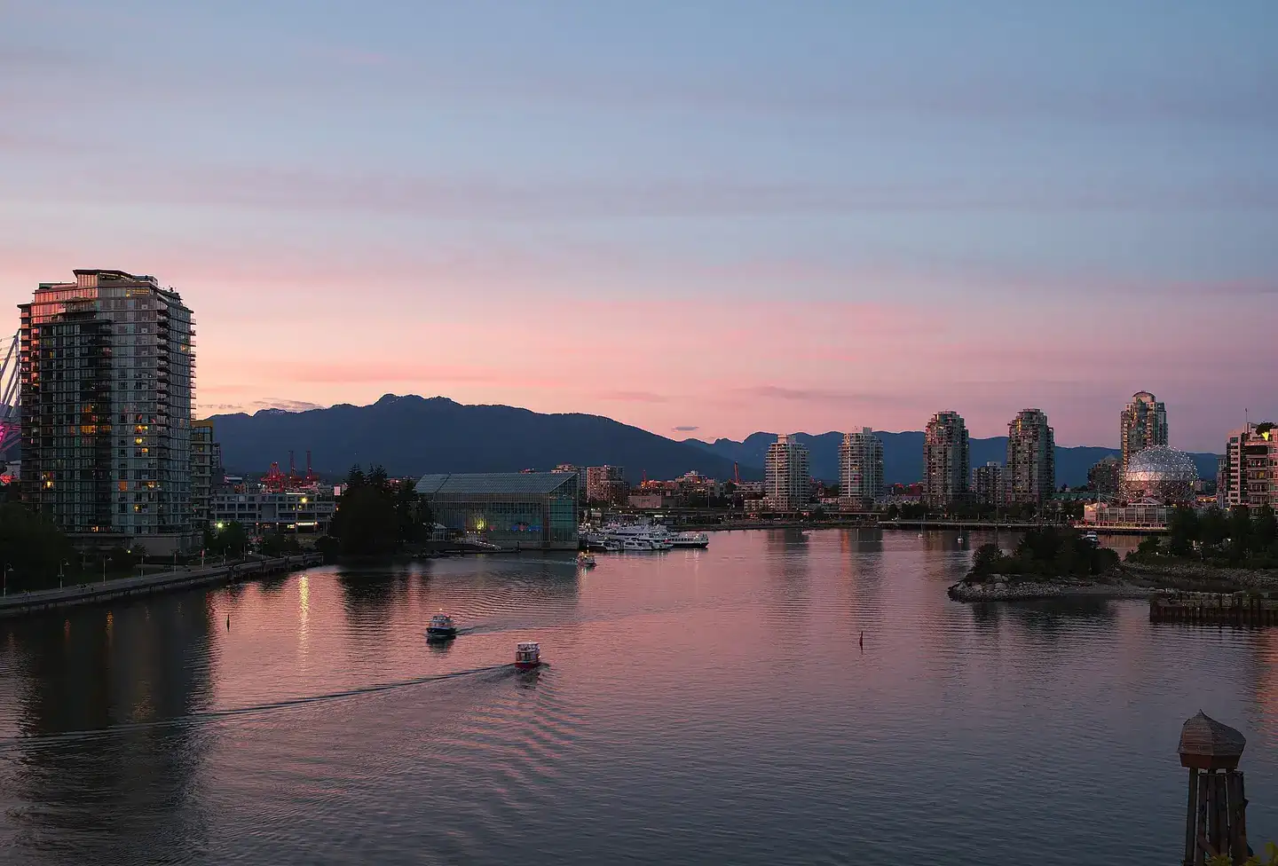 View of False Creek looking East from the Cambie Street Bridge during civil twilight in Vancouver, BC