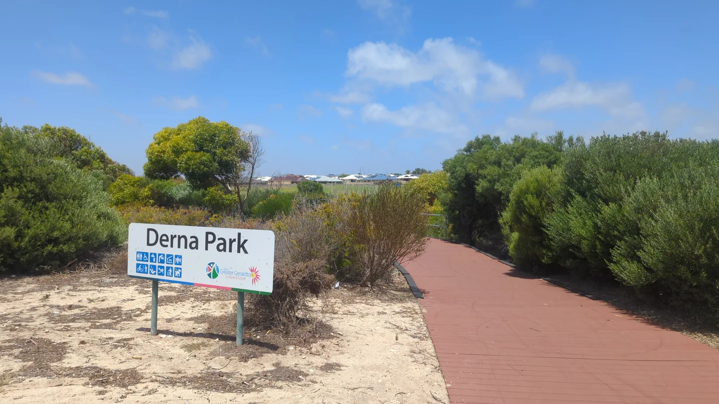 A smooth, level paved path leading into a coastal park