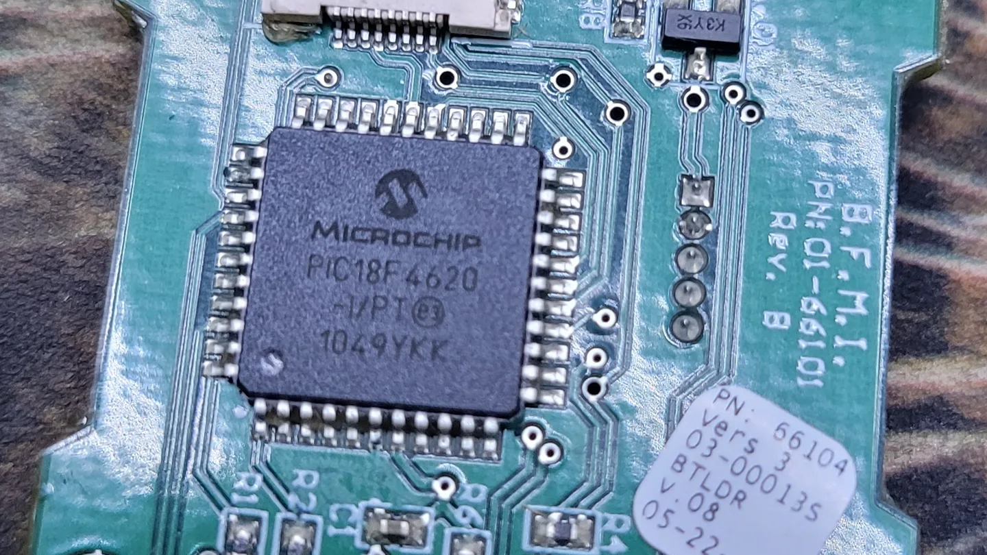 A green circuit board with a microcontroller chip