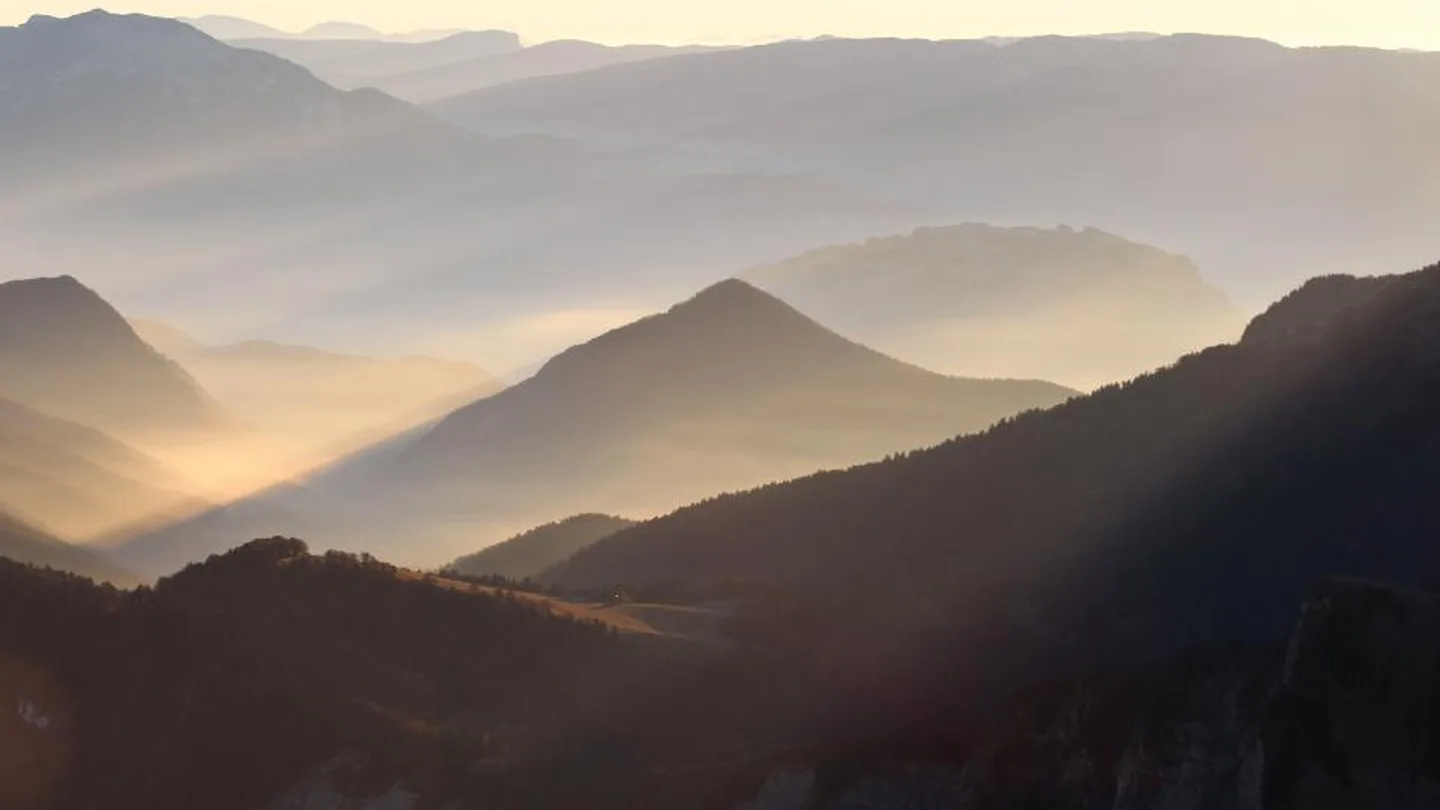 Morning light rising over layered mountain ridges